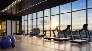 Fitness room at The Lighthauz featuring treadmill stations, strength equipment and open coastal views.