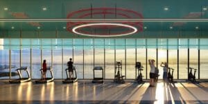 Horizon gym at Keeperz Suites with cardio equipment, open windows and sunset view across Penang